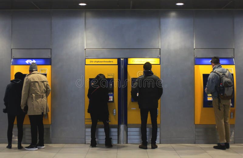 乌得勒支,荷兰,2019年2月15日:在支付的票机器前面的人们他们的与NS的旅途 图库摄影 乌得勒支,荷兰,2019年2月15日:在支付的票机器前面的人们他们的与NS的旅途 图库摄影