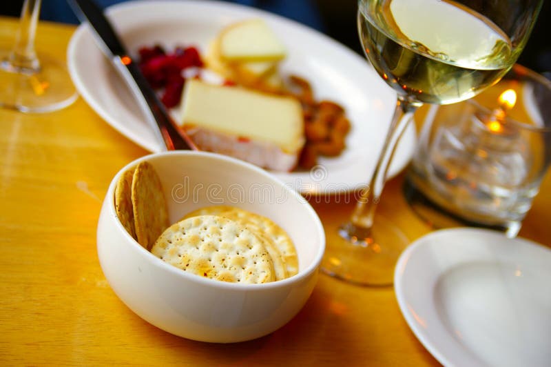 White wine with cheese and crackers on candle-lit table. White wine with cheese and crackers on candle-lit table