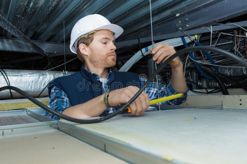 电工安装天花板灯的电缆 库存图片
