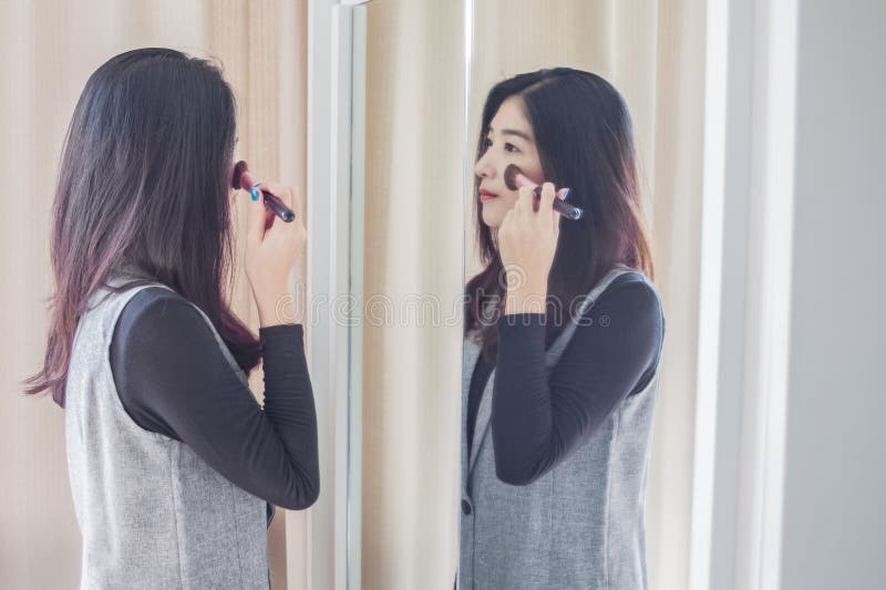 亚洲做与刷子的画象美丽的妇女构成在面孔 图库摄影 亚洲做与刷子的画象美丽的妇女构成在面孔 图库摄影