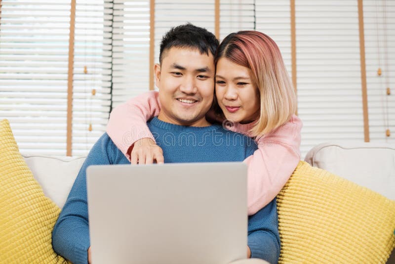 亚洲夫妇观看的录影在家住在在沙发的laptp客厅 一起花费时间的恋人 妻子容忍丈夫从 库存图片 亚洲夫妇观看的录影在家住在在沙发的laptp客厅 一起花费时间的恋人 妻子容忍丈夫从 库存图片