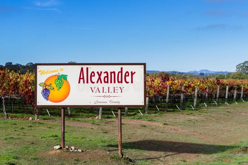 Welcome sign to Alexander Valley California with beautiful colorful vineyards in the background. Welcome sign to Alexander Valley California with beautiful colorful vineyards in the background