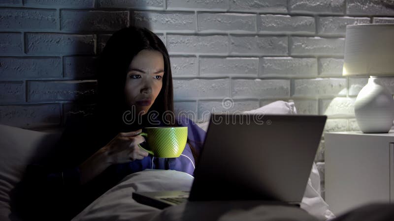 亚洲女人在卧室晚点用笔记本电脑喝咖啡 图库摄影 亚洲女人在卧室晚点用笔记本电脑喝咖啡 图库摄影