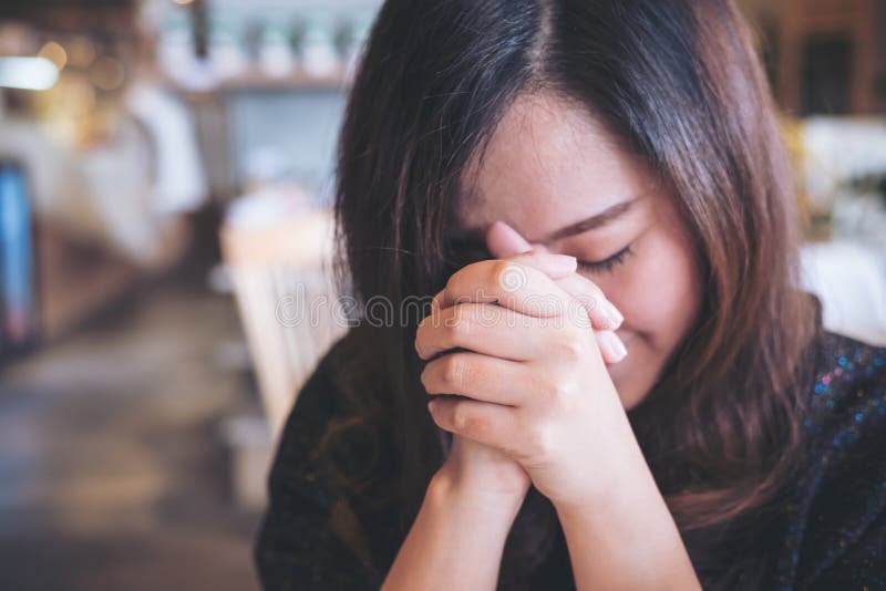 An Asian woman close her eyes to praying and wishing for a good luck. An Asian woman close her eyes to praying and wishing for a good luck