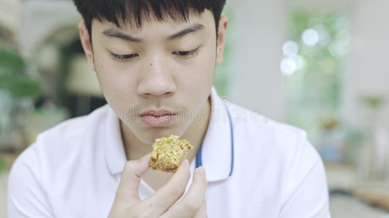 亚洲少年男孩一边吃零食一边用手机