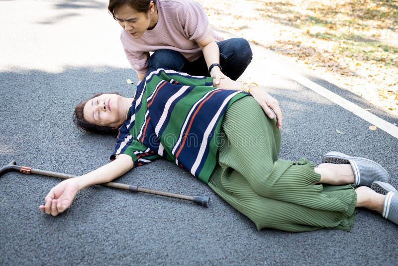 亚洲老年病人或母亲昏倒倒在地，女儿帮助、照顾、扶助，老年人