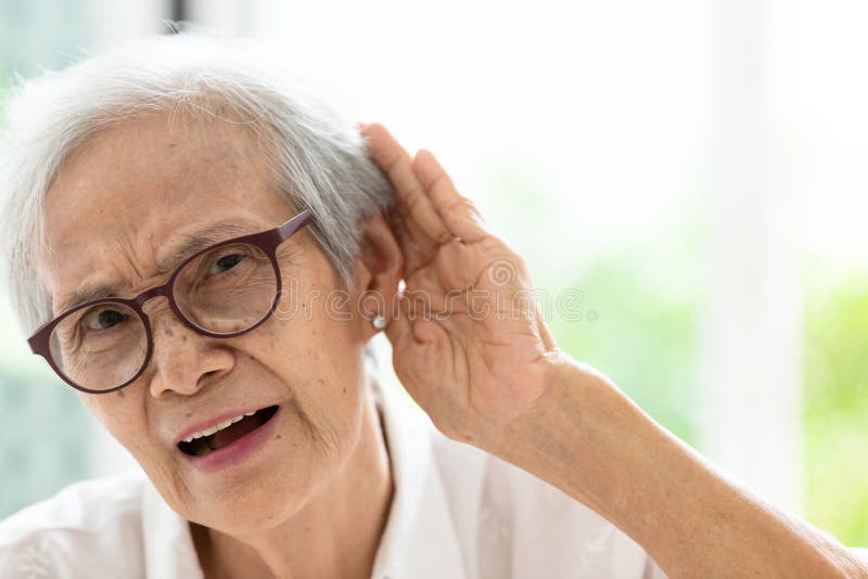 Asian senior woman listening by handâ€™s up to the ear,having difficulty in hearing,elderly woman hard to hear,wear glasses with hearing impairment,hearing impaired old people. Asian senior woman listening by handâ€™s up to the ear,having difficulty in hearing,elderly woman hard to hear,wear glasses with hearing impairment,hearing impaired old people