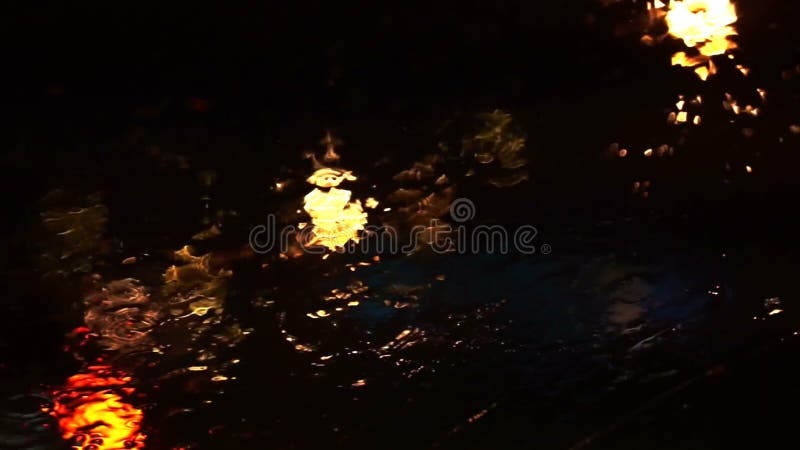 交通美好的五颜六色的模糊的光外面在路 雨流程和刮水器在汽车前面挡风玻璃玻璃