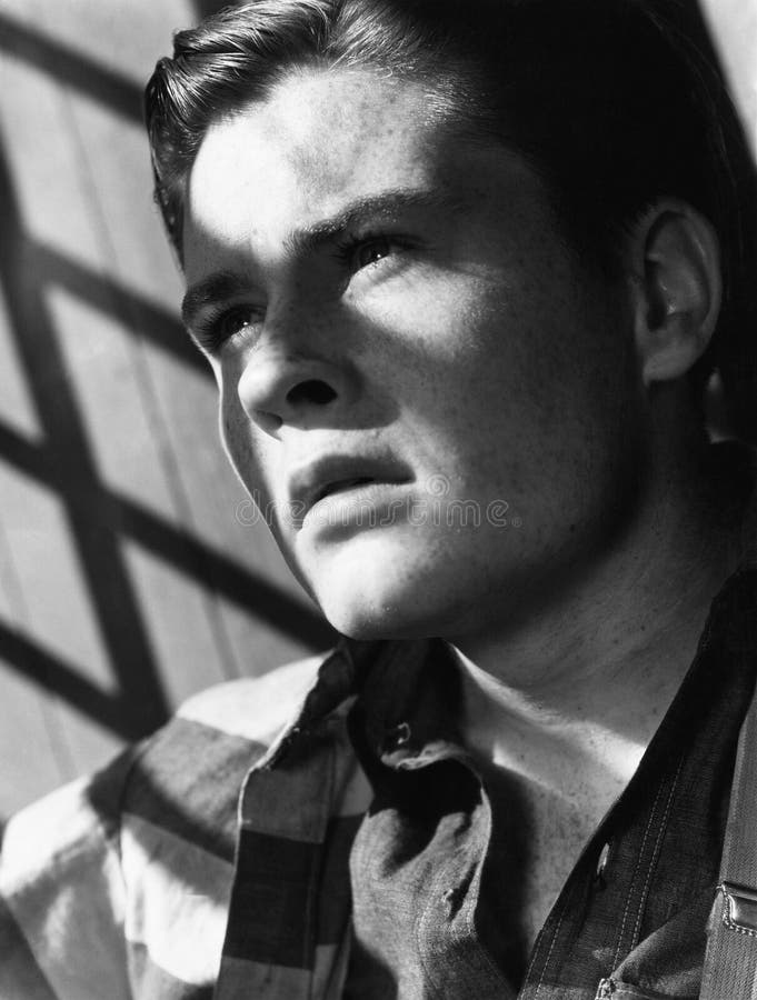 Portrait of young man with shadow of bars (All persons depicted are no longer living and no estate exists. Supplier grants that there will be no model release issues.). Portrait of young man with shadow of bars (All persons depicted are no longer living and no estate exists. Supplier grants that there will be no model release issues.)