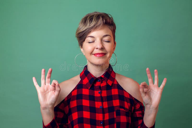 人们、情感和瑜伽概念-放松和微笑与眼睛的妇女画象闭上做与手指的凝思姿态 库存照片