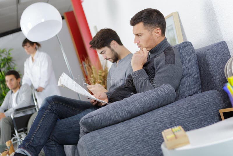 医院候诊室里的男人们 库存照片