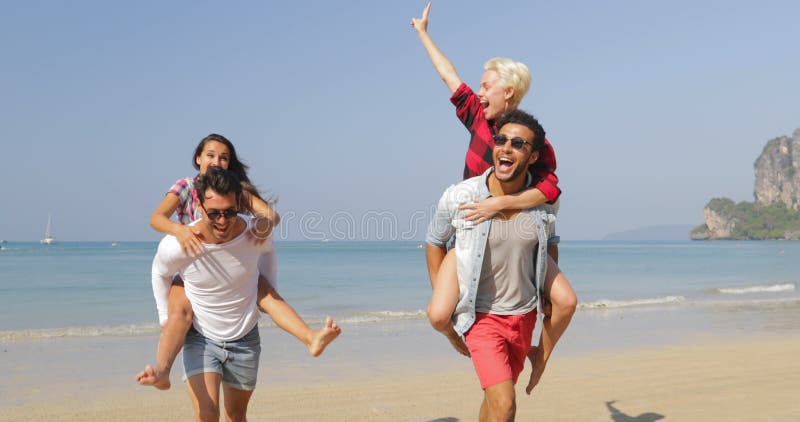人在度假运载妇女支持，跑在海滩愉快的快乐的人游人的两对夫妇
