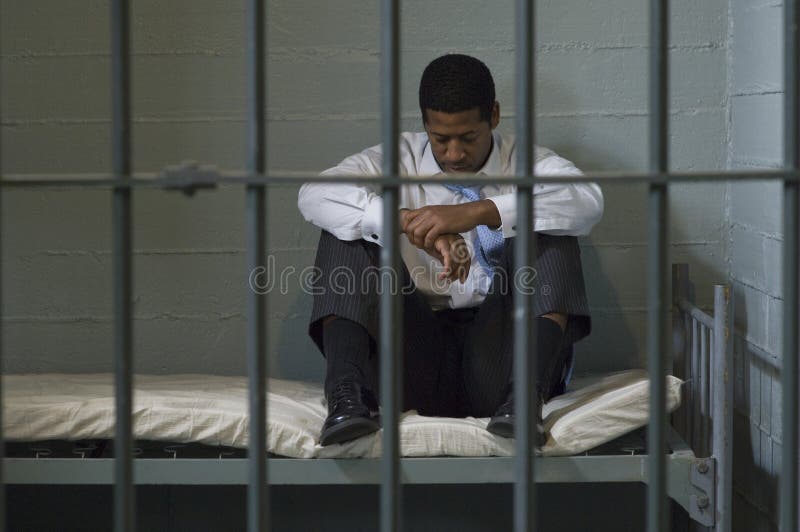 Businessman sitting on bed in prison cell. Businessman sitting on bed in prison cell