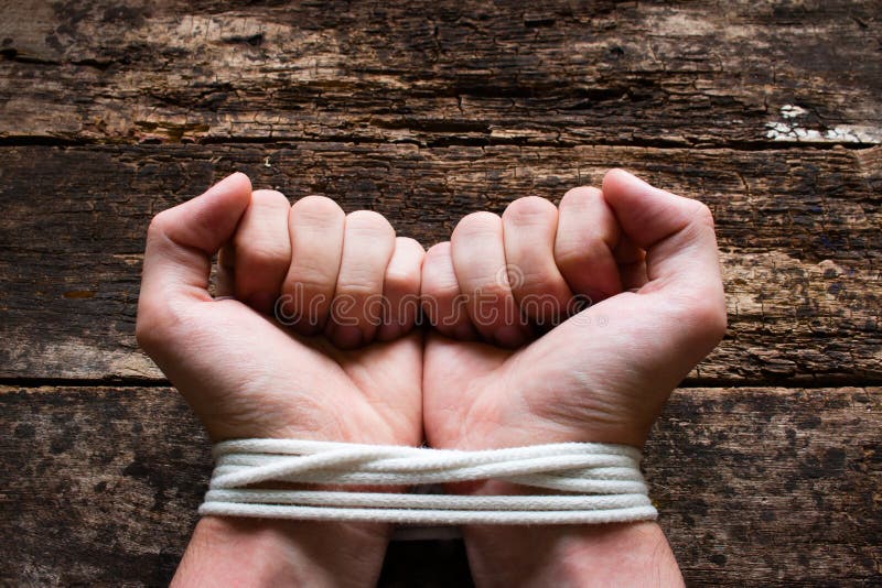 Man with his hands tied demonstrates that he is a slave. Man with his hands tied demonstrates that he is a slave