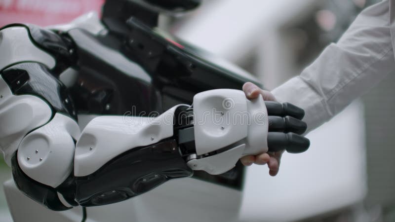 人的互作用和人工智能现代技术  关闭科学家的男性手震动机器人
