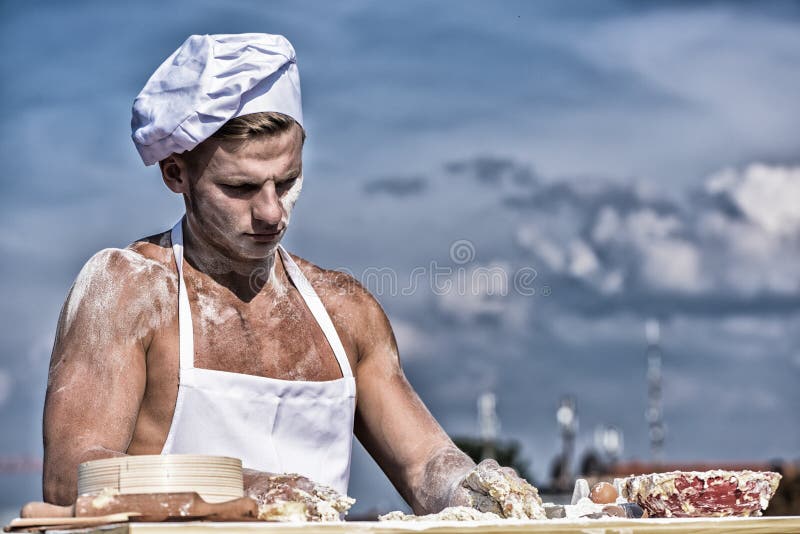 Man muscular baker or cook kneading dough in bowl. Bakery concept. Baker at working surface covered with flour, kneading dough by hands. Hands of chef cook covered with sticky dough and flour. Man muscular baker or cook kneading dough in bowl. Bakery concept. Baker at working surface covered with flour, kneading dough by hands. Hands of chef cook covered with sticky dough and flour.
