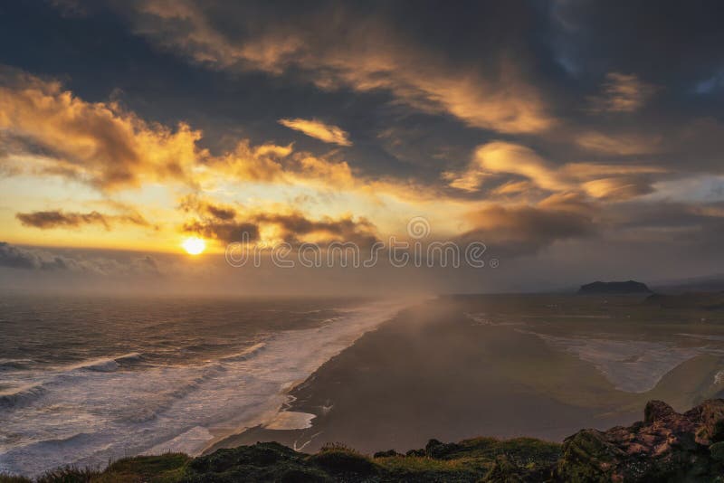 从冰岛的迪尔霍莱观点看黑沙滩上的夕阳 免版税图库摄影 从冰岛的迪尔霍莱观点看黑沙滩上的夕阳 免版税图库摄影