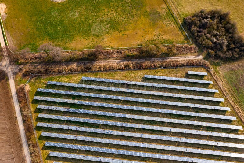 A PV open space plant, bushes, farm tracks and meadows in Germany from a drone view. A PV open space plant, bushes, farm tracks and meadows in Germany from a drone view