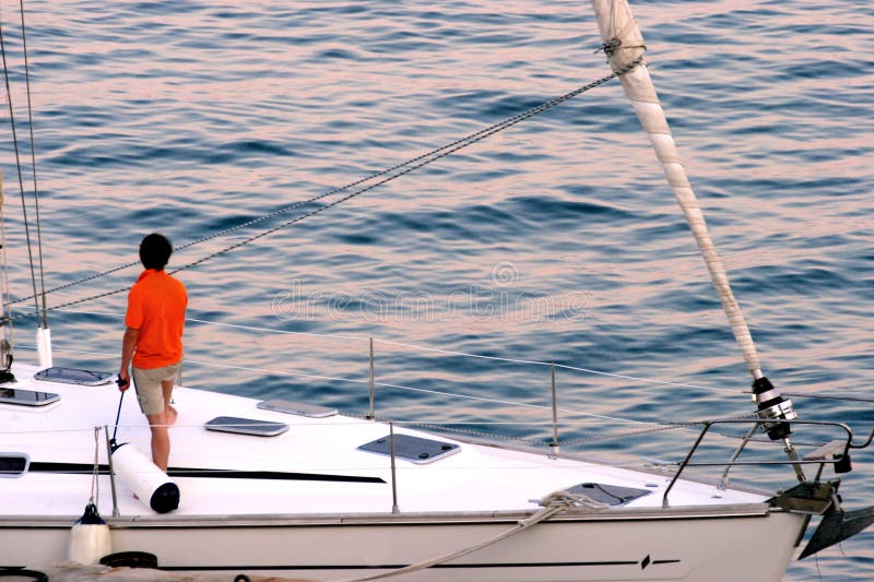 Man enjoying the sunset on his sailboat. Man enjoying the sunset on his sailboat.