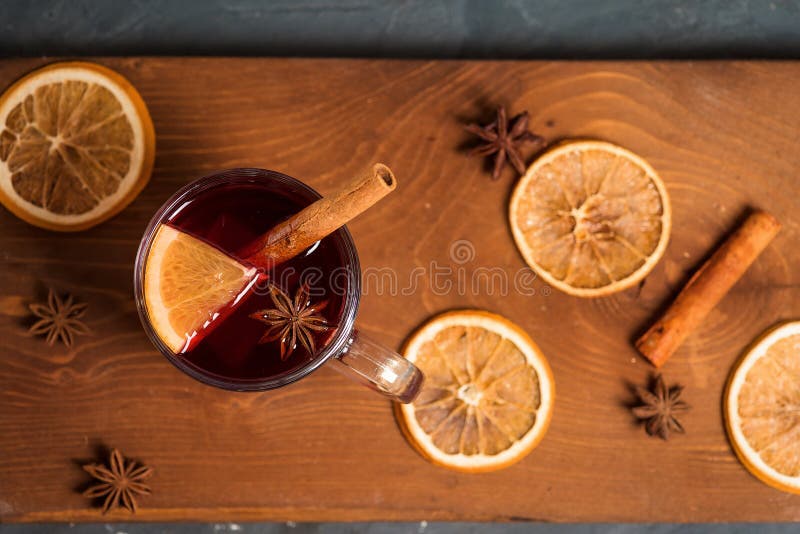 Winter spicy drink mulled wine based on red wine, spices and orange. on a dark wooden background. close-up, space for text . the view from the top. Winter spicy drink mulled wine based on red wine, spices and orange. on a dark wooden background. close-up, space for text . the view from the top.