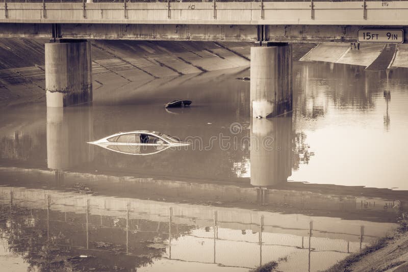 A 15 feet and 9 inches tollway bridge with flooded cars underneath. Swamped sedan vehicles under highway road near downtown Houston, Texas. A 15 feet and 9 inches tollway bridge with flooded cars underneath. Swamped sedan vehicles under highway road near downtown Houston, Texas