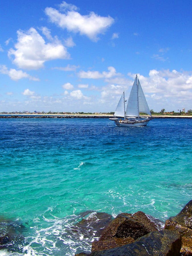 A Sailboat is coming through a Florida inlet. A Sailboat is coming through a Florida inlet.