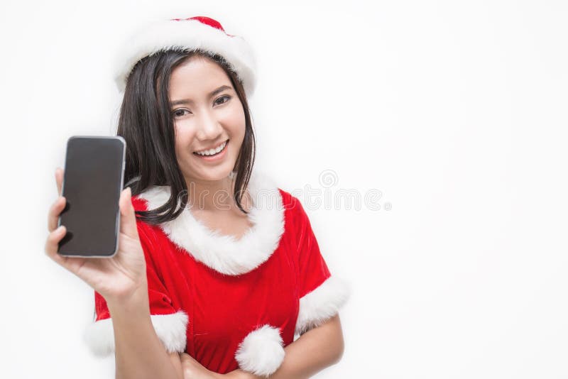Portrait of asian beautiful woman wearing santa custume with her hand holding mobil phone. Smiling happy asian girl isolated on white background. Christmas party and holiday concept. Portrait of asian beautiful woman wearing santa custume with her hand holding mobil phone. Smiling happy asian girl isolated on white background. Christmas party and holiday concept