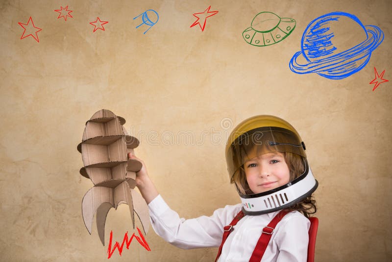 Kid astronaut with cardboard toy rocket. Child playing at home. Earth day concept. Kid astronaut with cardboard toy rocket. Child playing at home. Earth day concept