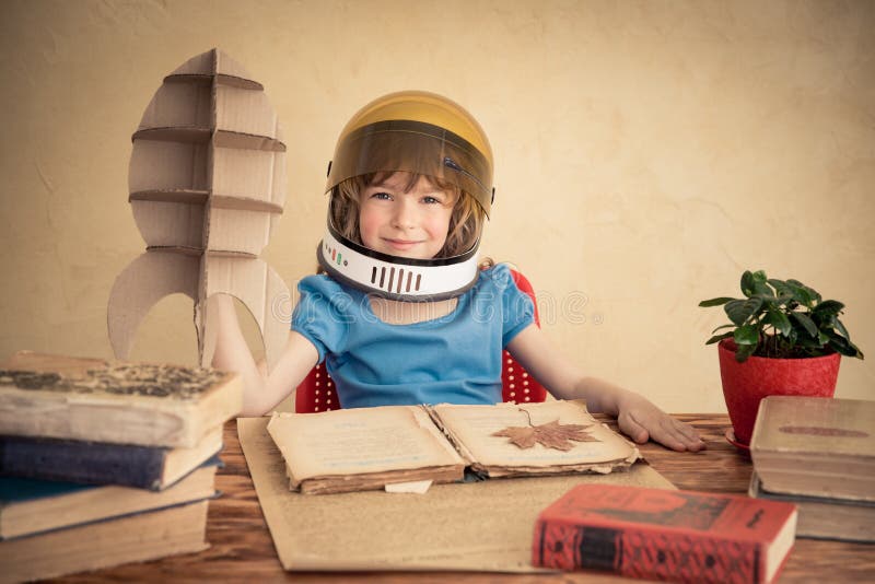 Kid astronaut with cardboard toy rocket. Child playing at home. Earth day concept. Kid astronaut with cardboard toy rocket. Child playing at home. Earth day concept