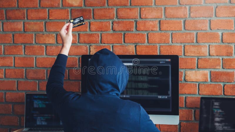使用信用卡的危险戴头巾黑客键入坏数据入计算机在线系统和传播对全球性被窃取的个人 免版税库存图片 使用信用卡的危险戴头巾黑客键入坏数据入计算机在线系统和传播对全球性被窃取的个人 免版税库存图片