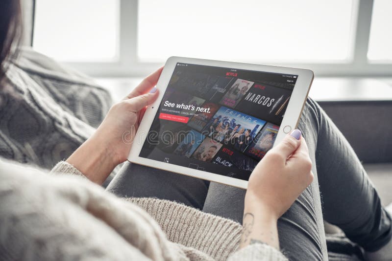 Kiev, Ukrain - February 10, 2018: Woman using Netflix app on a brand new Apple iPad Pro Silver, 7th generation of the iPad, developed by Apple inc. and was announced on March 21, 2016. Kiev, Ukrain - February 10, 2018: Woman using Netflix app on a brand new Apple iPad Pro Silver, 7th generation of the iPad, developed by Apple inc. and was announced on March 21, 2016