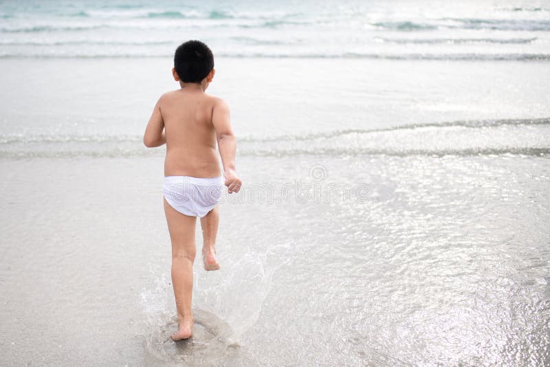 使用在沙滩的男孩 愉快的孩子在度假在海边在度假夏天休假 孩子本质上与海、沙子和天空蔚蓝的 图库摄影