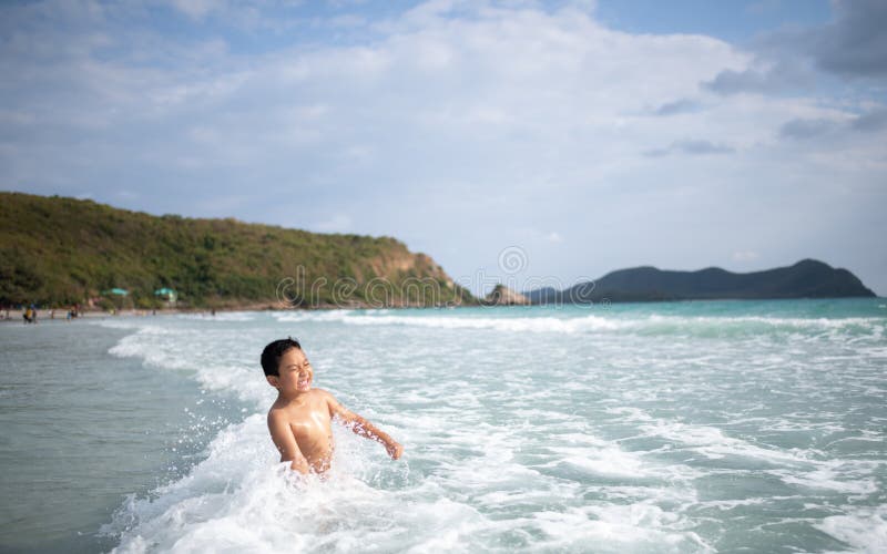 使用在沙滩的男孩 愉快的孩子在度假在海边在度假夏天休假 孩子本质上与海、沙子和天空蔚蓝的 图库摄影