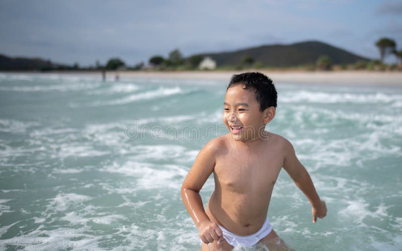 使用在沙滩的男孩 愉快的孩子在度假在海边在度假夏天休假 孩子本质上与海、沙子和天空蔚蓝的 库存图片