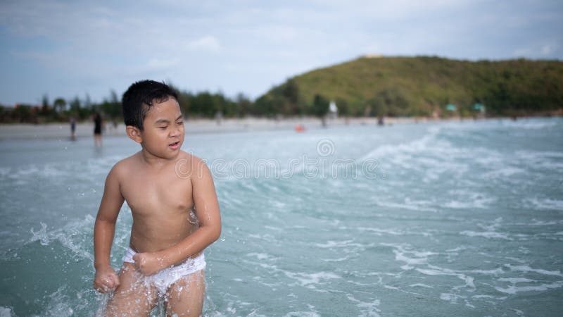 使用在沙滩的男孩 愉快的孩子在度假在海边在度假夏天休假 孩子本质上与海、沙子和天空蔚蓝的 图库摄影