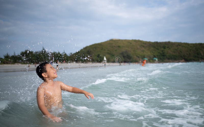 使用在沙滩的男孩 愉快的孩子在度假在海边在度假夏天休假 孩子本质上与海、沙子和天空蔚蓝的 库存图片