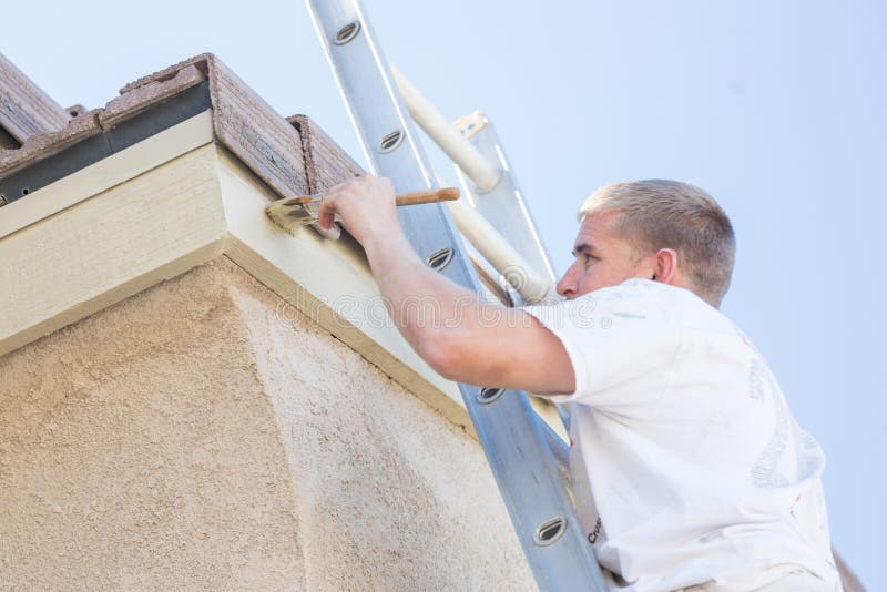 Professional Painter Using A Small Roller to Paint House Fascia. Professional Painter Using A Small Roller to Paint House Fascia.