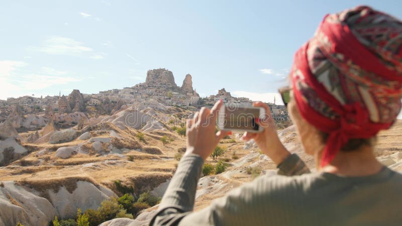 使用手机，年轻混合的族种旅游女孩为沙漠谷照相 Cappadocia，土耳其 4K 影视素材