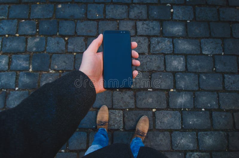 使用智能手机的男性手在街道上 技术和人脉的概念 有手表的商人,外套和采取酸碱度 库存图片 使用智能手机的男性手在街道上 技术和人脉的概念 有手表的商人,外套和采取酸碱度 库存图片
