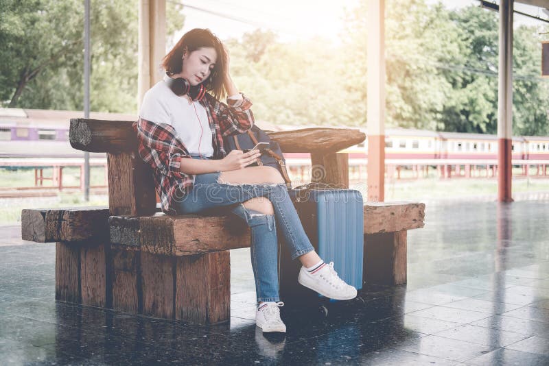 使用有行李的旅客女孩片剂坐和等待fo 图库摄影 使用有行李的旅客女孩片剂坐和等待fo 图库摄影