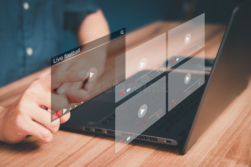 使用电脑笔记本电脑在网上观看足球直播的男子在虚拟屏幕上搜索互联网视频. 免版税库存照片