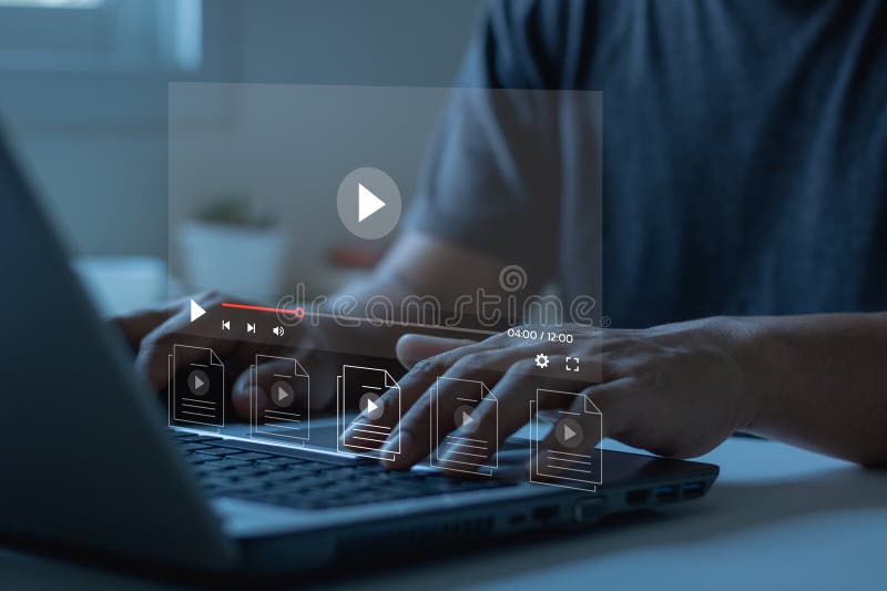 男人使用笔记本电脑在虚拟屏幕上进行在线直播，观看互联网上的视频，现场音乐会、表演或教程 库存照片