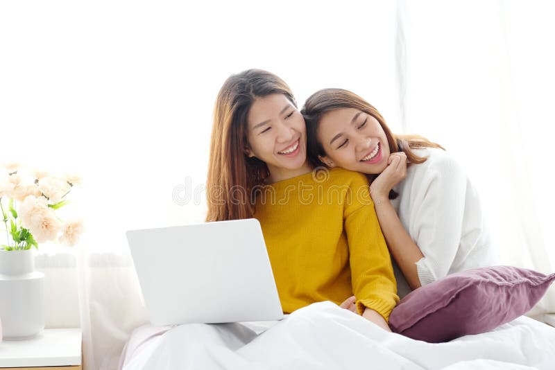 使用膝上型计算机的年轻逗人喜爱的亚洲女同性恋的夫妇充满幸福在ho 库存照片 使用膝上型计算机的年轻逗人喜爱的亚洲女同性恋的夫妇充满幸福在ho 库存照片