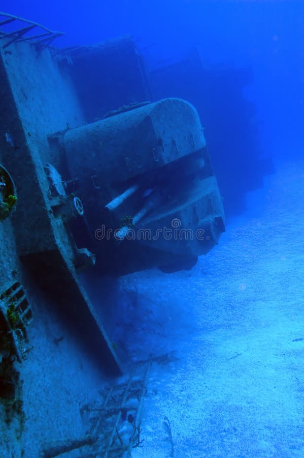 Image is of a shipwreck, the Tibbetts, Cayman Brac. It is receding on the diagonal into the blue ocean; the guns of this Russian warship can clearly be seen center page. No divers are evident, it is a peaceful image of a once warmongering vessel. Image is of a shipwreck, the Tibbetts, Cayman Brac. It is receding on the diagonal into the blue ocean; the guns of this Russian warship can clearly be seen center page. No divers are evident, it is a peaceful image of a once warmongering vessel.