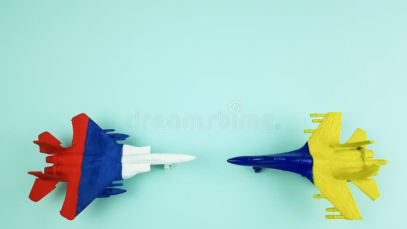 models of Russian and Ukrainian military aircraft are painted in the colors of national flags on a light background.military operation. models of Russian and Ukrainian military aircraft are painted in the colors of national flags on a light background.military operation.