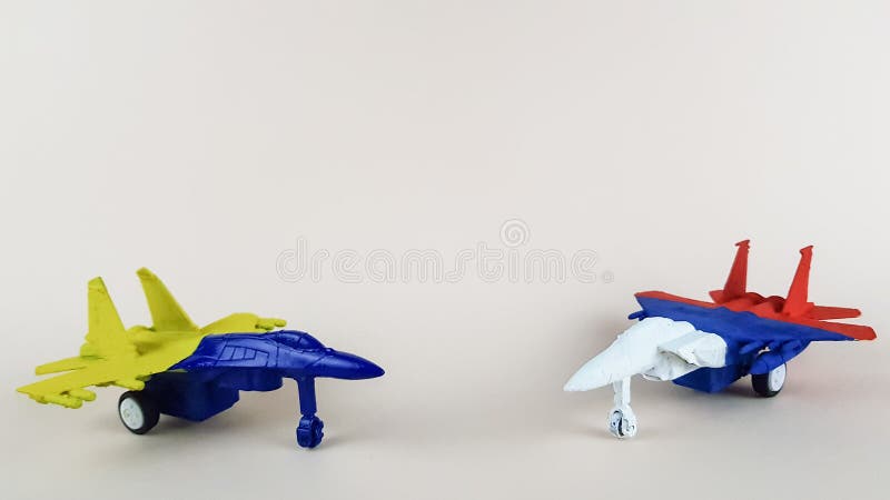 models of Russian and Ukrainian military aircraft are painted in the colors of national flags on a light background.military operation. models of Russian and Ukrainian military aircraft are painted in the colors of national flags on a light background.military operation.
