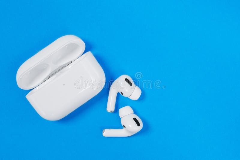 Rostov, Russia - July 06, 2020: Wireless headphones Apple AirPods Pro in opened charging case with active noise cancellation immersive sound, on blue background, copy space. Rostov, Russia - July 06, 2020: Wireless headphones Apple AirPods Pro in opened charging case with active noise cancellation immersive sound, on blue background, copy space