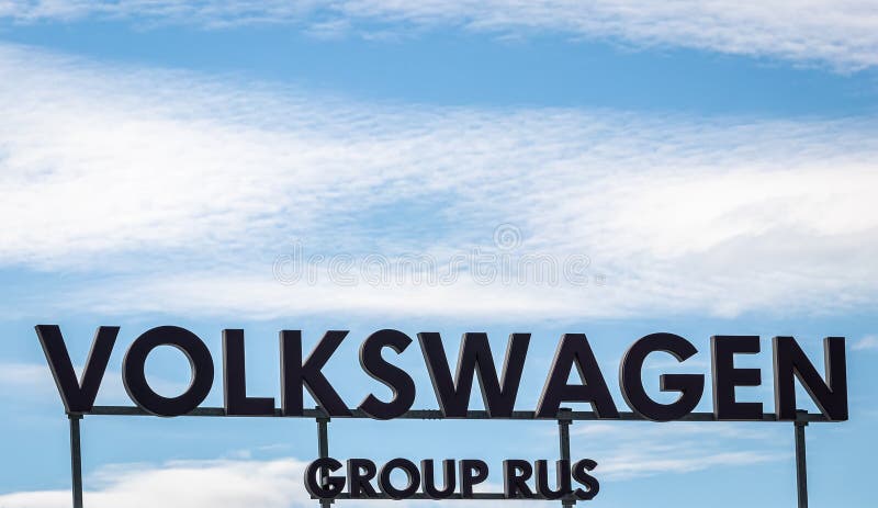 Russia, Kaluga - SEPTEMBER 29, 2020: Metallic Volkswagen Group Rus logo on a blue sky background. Automobile plant in Russia. Russia, Kaluga - SEPTEMBER 29, 2020: Metallic Volkswagen Group Rus logo on a blue sky background. Automobile plant in Russia