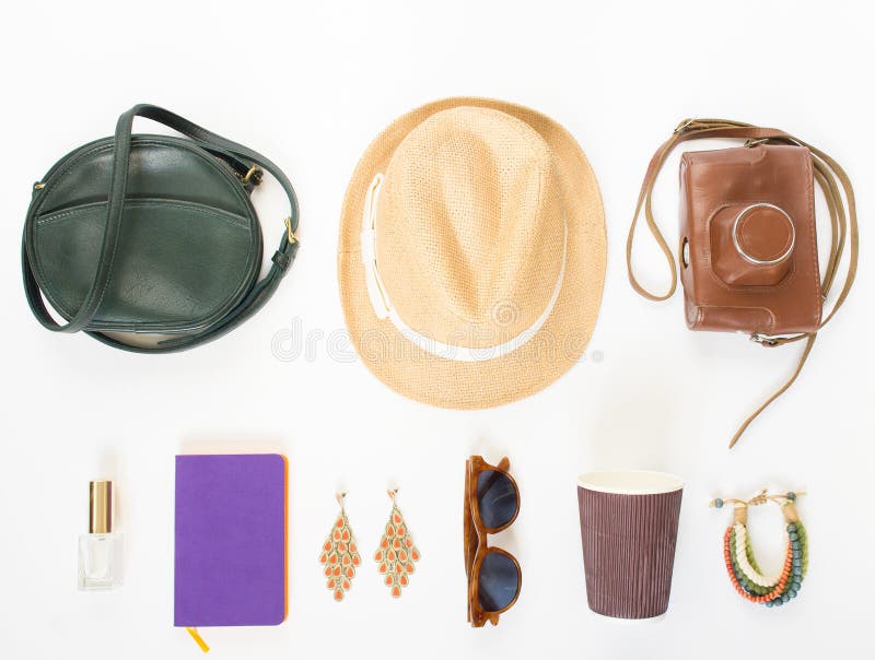 Holiday, travel background. Green cross bag, straw hat, retro brown sunglasses, retro camera, hippie bracelet and earrings, violet noutbook, coffee cup. Flat lay, top view. Holiday, travel background. Green cross bag, straw hat, retro brown sunglasses, retro camera, hippie bracelet and earrings, violet noutbook, coffee cup. Flat lay, top view