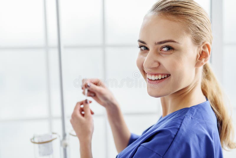 Smiling doctor making drop bottle in hospital office. Smiling doctor making drop bottle in hospital office